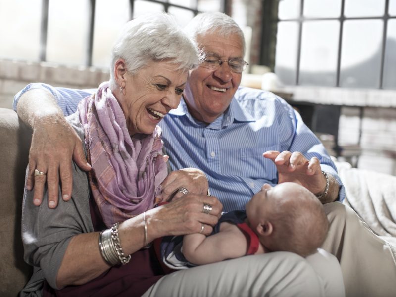 Grandparents playing with granddaughter at home