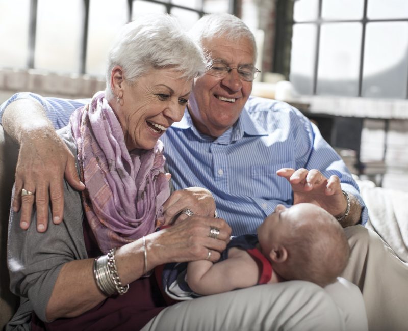 Grandparents playing with granddaughter at home